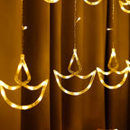 Full view of 12 Diya Curtain String Lights creating a warm glow in a home setting.