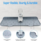 The silicone faucet mat positioned under a kitchen faucet, illustrating its water-channeling design.