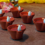Hand pouring water into a water sensor diya, showing it light up.