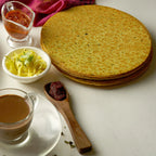 Maniarr's Masala Khakhra presented on a plate, surrounded by fresh spices, emphasizing natural ingredients.