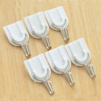 Self-adhesive hook blending seamlessly on a white tiled bathroom wall.