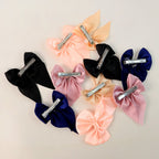 Collection of satin bow hair clips arranged neatly
